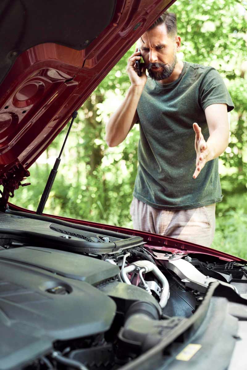 Junger Mann prüft Getriebeschaden bei Schrottauto Ankauf Geesthacht